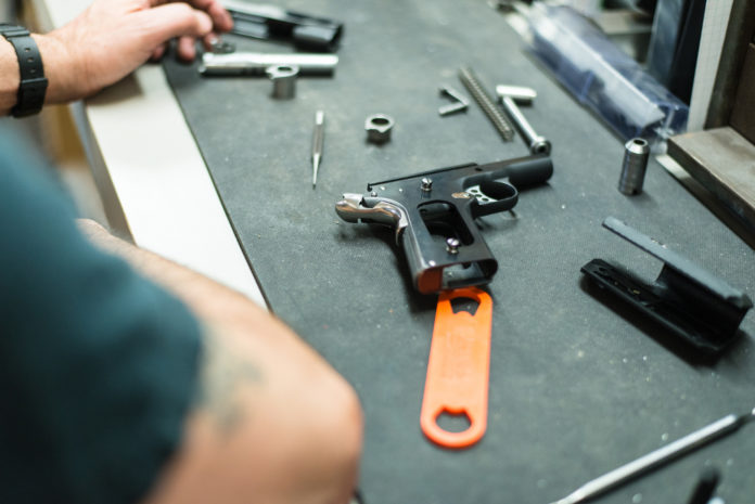 pistola smontata sul banco dell'armaiolo: corsi per licenze armi 2019